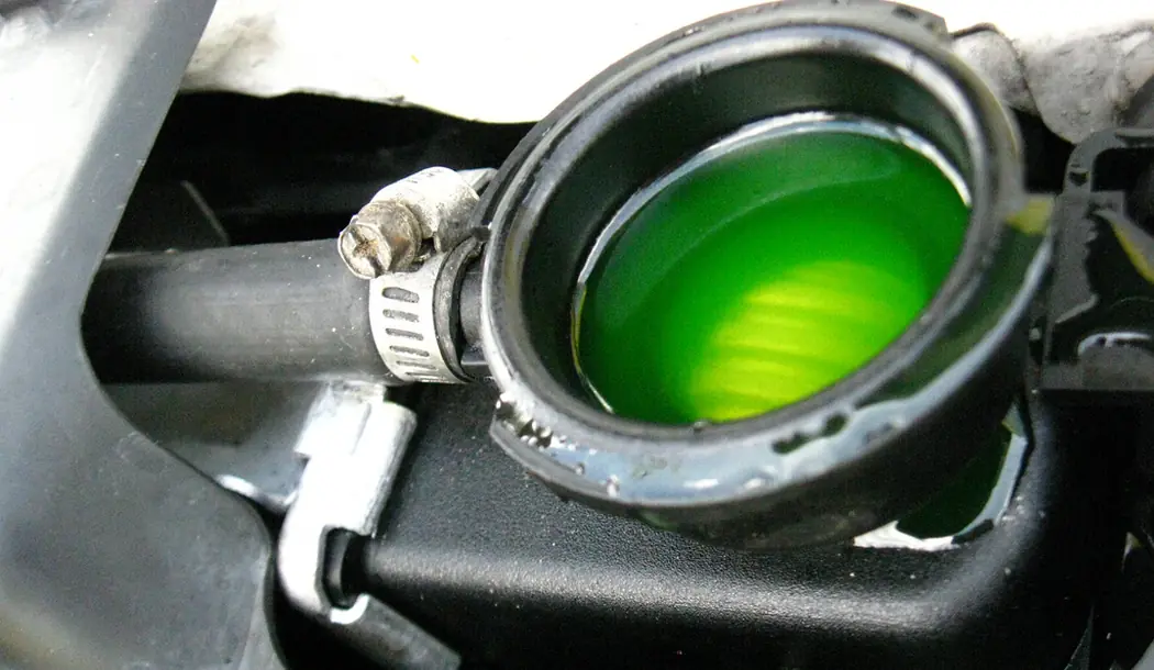 Green or orange puddle under the car